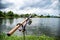 A fishing reel placed in a fishing rod buried in a pond, waiting for the fish