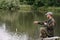 Fishing in river.A fisherman with a fishing rod on the river bank. Man fisherman catches a fish pike.Fishing, spinning