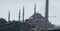Fishing rod in front of the deliberately blurred backdrop of a mosque with dome and minarets.