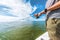 Fishing rod wheel man fishing from fisherman boat in Florida. Wearing smartwatch wearable technology for outdoor sport