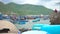 Fishing ships and boats on parking in sea on green mountain background. Traditional basket fishing boats and ships