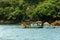 Fishing trawler anchored along the rocks and forest by the sea