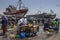 A fishing trawler sits in dry dock as a fish monger sells fish at Essaouira in Morocco.