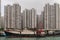 Fishing vessel docked in front of tall buildings in harbor of Hong Kong, China