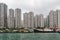 Fishing vessel docked in front of tall buildings in harbor of Hong Kong, China