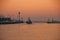 A Fishing vessel moves toward the sea at sunrise, Italy.
