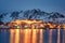 Fishing village glowing on coastline with snowy mountain at Nordland, Lofoten islands