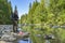 Fishing at wild mountain river. Fisherman catch trout fish at stone coast of forest stream