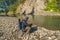 Fishing at wild mountain river. Fisherman catch trout fish at stone coast of forest stream