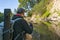 Fishing at wild mountain river. Fisherman catch trout fish at stone coast of forest stream