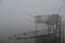 Fishing wooden hut in winter fog. Valli di Comacchio, Italy.