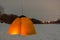 Fishing yellow winter tent is glowing with the light of candles inside with the shadow of a fisherman on the snowy ice of the