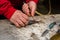 Fishmonger cutting a small fish on a cutting board