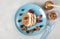 Fishs-shaped pancake with peaches, berries, granola and almonds on a blue plate, breakfast idea for kids, top view