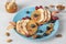 Fishs-shaped pancakes with peaches, berries, granola and almonds on blue plate, healthy breakfast idea for kids