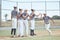 Fist bump, teamwork and sport team support in baseball game on pitch field outdoors. Baseball player, running and