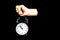 Fist Punching Down on Alarm Clock on Black Background