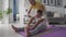 Fit active mature wife helping senior husband doing stretching exercise at home.