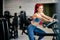 Fit active woman in the gym, working out on stationary bicycle at local gym.  Fitness and bodybuilding concept