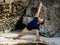 Fit Asian man practicing yoga on the beach. Standing pose Parivrtta Parsvakonasana. Revolved Side Angle Pose. Strong flexible body