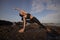 Fit Asian woman practicing yoga on the beach. Standing pose Parivrtta Parsvakonasana. Revolved Side Angle Pose. Strong flexible