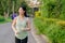 Fit Asian young woman jogging in park smiling happy running and enjoying a healthy outdoor lifestyle. Female jogger. Fitness