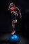 Fit athlete performing exercise on gymnastic hemisphere bosu ball on dark studio