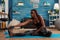 Fit black woman stretching reaching toes sitting on yoga mat