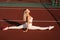 Fit blonde girl does front leg spirit workout exercise outdoor. Attractive girl trains outside. Sports lifestyle.