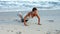 Fit brunette doing press ups on the beach