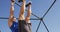 Fit caucasian man exercising outside, doing leg raises on a climbing frame