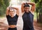 Fit couple or active, athlete friends stretching arms for exercise warmup outdoors in forest. Workout partners or