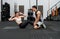 Fit couple exercising together in a well-equipped gym, engaged in a dynamic strength training workout. An image reflecting