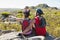 Fit cyclist couple sitting at the summit looking around