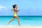 Fit female athlete girl runner running on beach