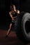 Fit female athlete performing a tire flip