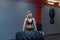 Fit female athlete working out with a huge tire, turning and carry in the gym. Crossfit woman exercising with big tire