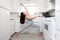 Fit female cooking and exercising at the same time, funny lifestyle advertisement, yoga pose in tiny home