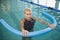 Fit female swimming with foam roller in pool