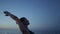 Fit girl performing virabhadrasana on beach closeup. Woman standing warrior pose