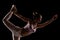 Fit girl practicing yoga in a studio. Half silhouette side lit fitness model