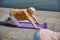 Fit gray-haired yogi working out on the quay