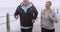 Fit, happy and mature couple jogging together along the ocean while talking. Wife points out the view ahead to husband