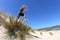 Fit, healthy middle aged man leaping over sand dunes