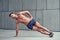 Fit healthy muscular young man with a bare chest doing side planks