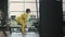 Fit hispanic woman performing weight lifting deadlift exercise with dumbbell at gym In yellow sportswear. woman brunette