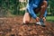 Fit male jogger ties shoes while day training for cross country forest trail race in a nature park.