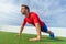 Fit man doing push ups exercise at outdoor gym. Core body workout athlete planking or doing pushup on grass