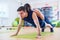 Fit man doing push-ups with woman on back in gym using own weight. Sport training arms, teamwork.