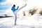 Fit man practicing a kick shot outdoor in snow. Fitness player training